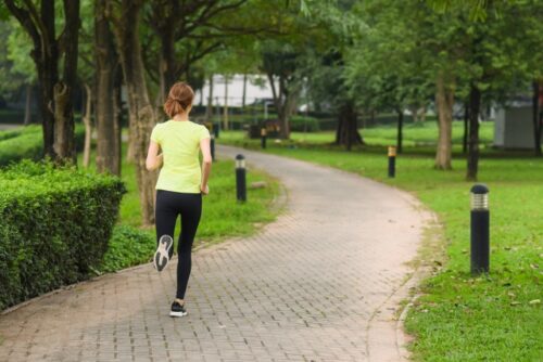 若い女性が公園で颯爽と走っている